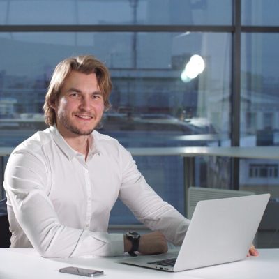 portrait-modern-attractive-businessman-working-desk-office-using-laptop_186451-174